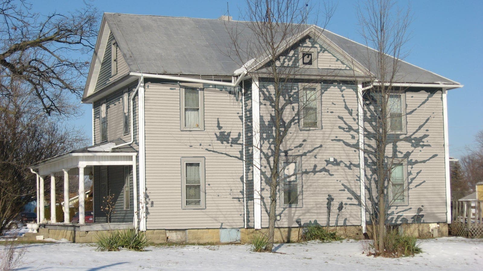 Two-story farmhouse with lap siding and a metal roof, repainted: siding Accessible Beige SW 7036