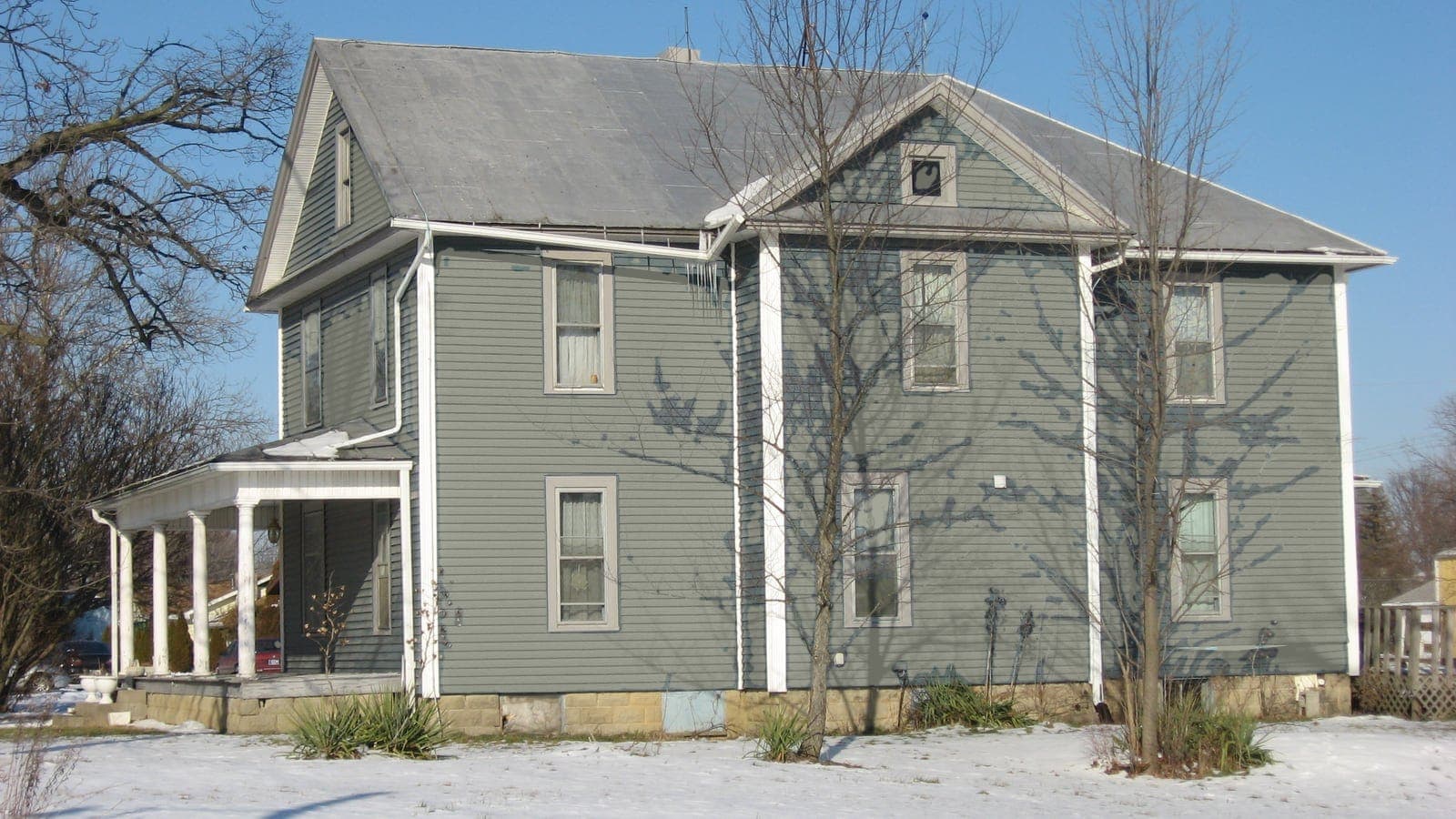 Two-story farmhouse with lap siding and a metal roof, repainted: siding Evergreen Fog SW 9130