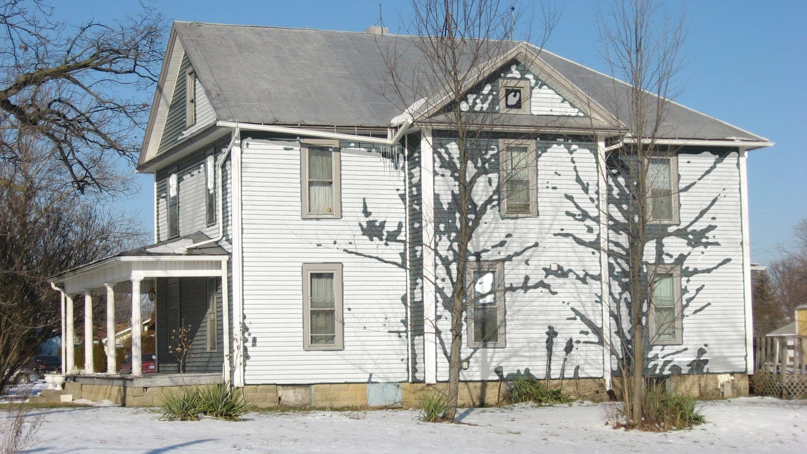 Two-story farmhouse with lap siding and a metal roof, repainted: siding Extra White SW 7006