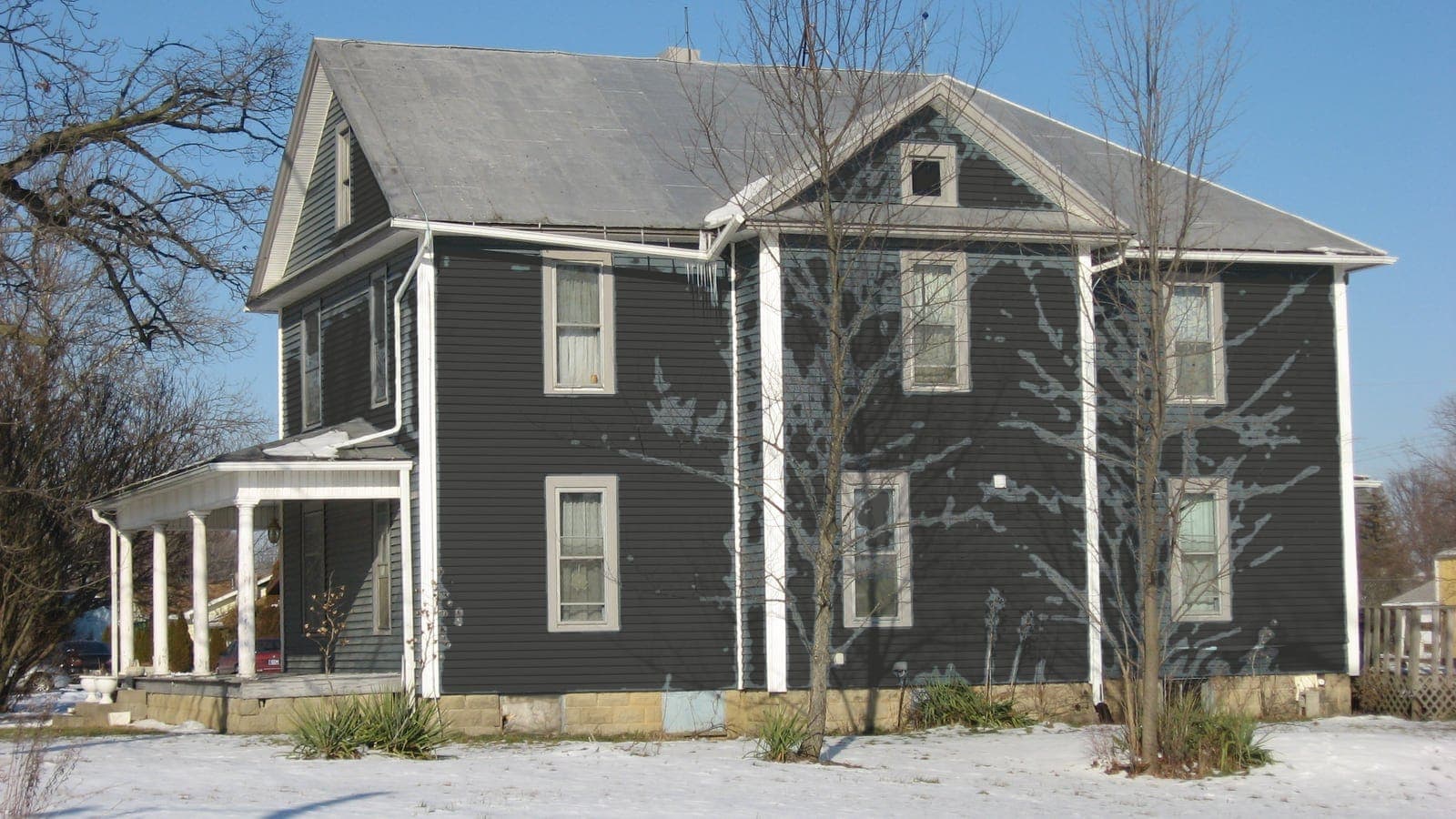 Two-story farmhouse with lap siding and a metal roof, repainted: siding Iron Ore SW 7069